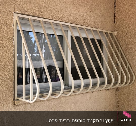 סורגי מתכת לבנים על חלון זכוכית